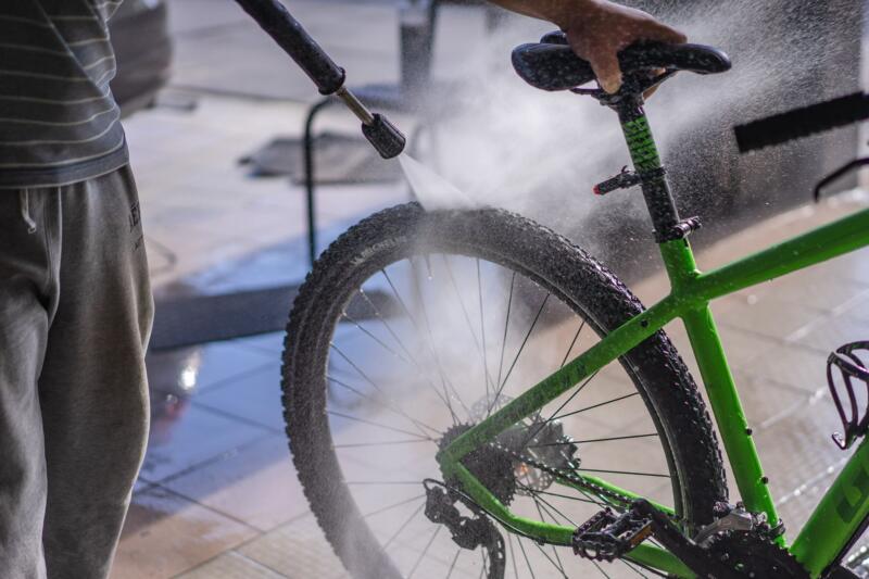Limpieza de bicicleta al aire libre con manguera portátil