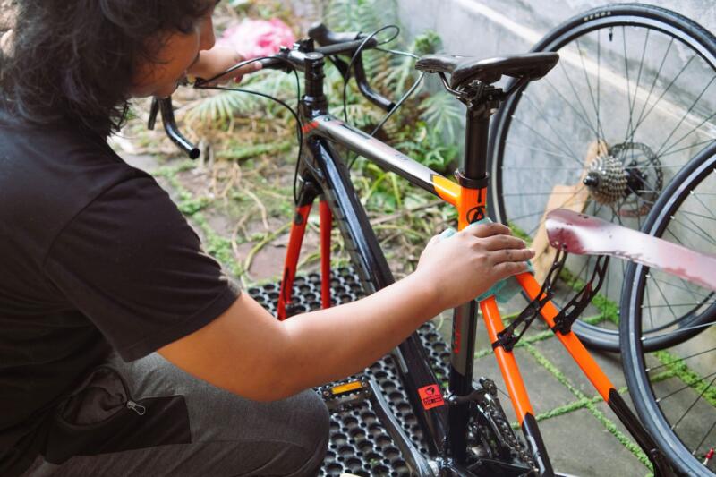 Persona limpiando una bicicleta al aire libre